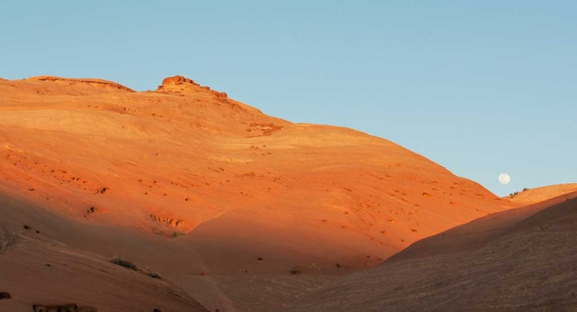 A red mountainous landscape rests under a blue sky
